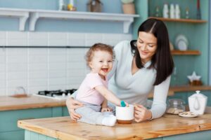 A smiling baby with their babysitter playing at home in Budapest